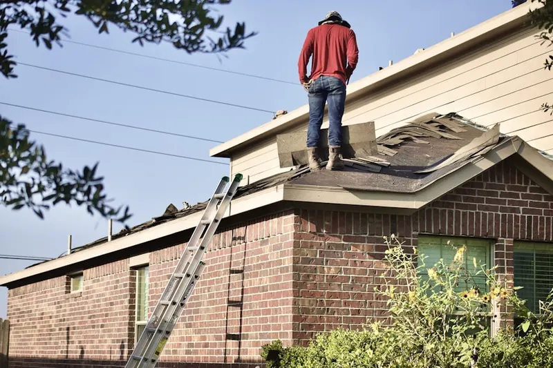 Professional roofer working on a residential roof in Victory
